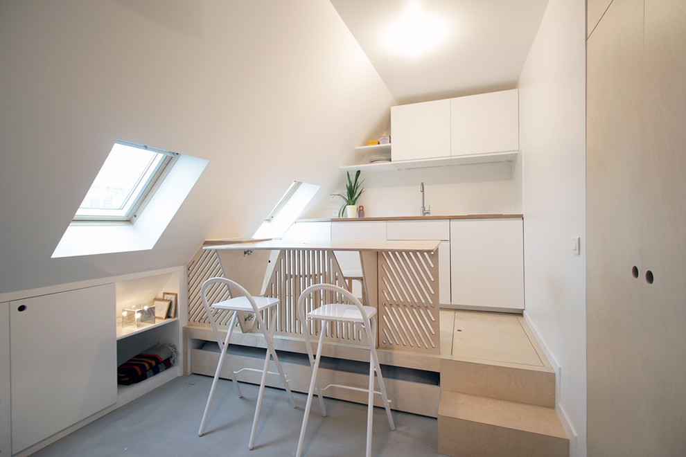 Kleines Modernes Esszimmer ohne Kamin mit weißer Wandfarbe und hellem Holzboden in Paris