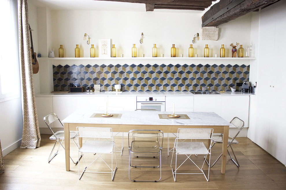 Inspiration pour une salle à manger ouverte sur le salon bohème de taille moyenne avec parquet clair, un mur blanc et un sol marron.