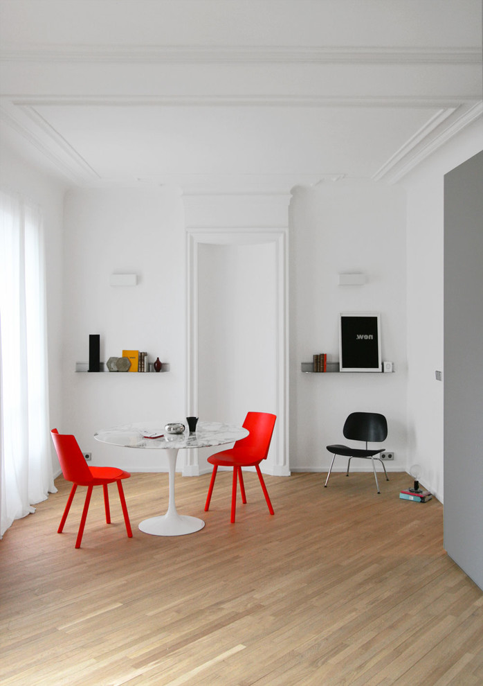 Modernes Esszimmer mit weißer Wandfarbe und hellem Holzboden in Paris