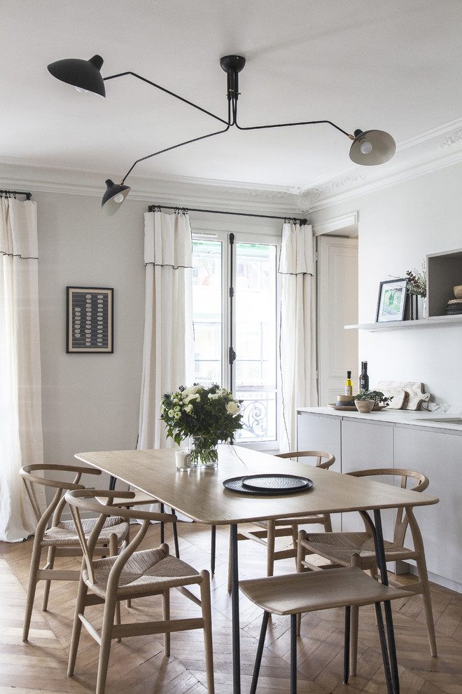 Inspiration for a medium sized scandi open plan dining room in Paris with light hardwood flooring, white walls, no fireplace and brown floors.
