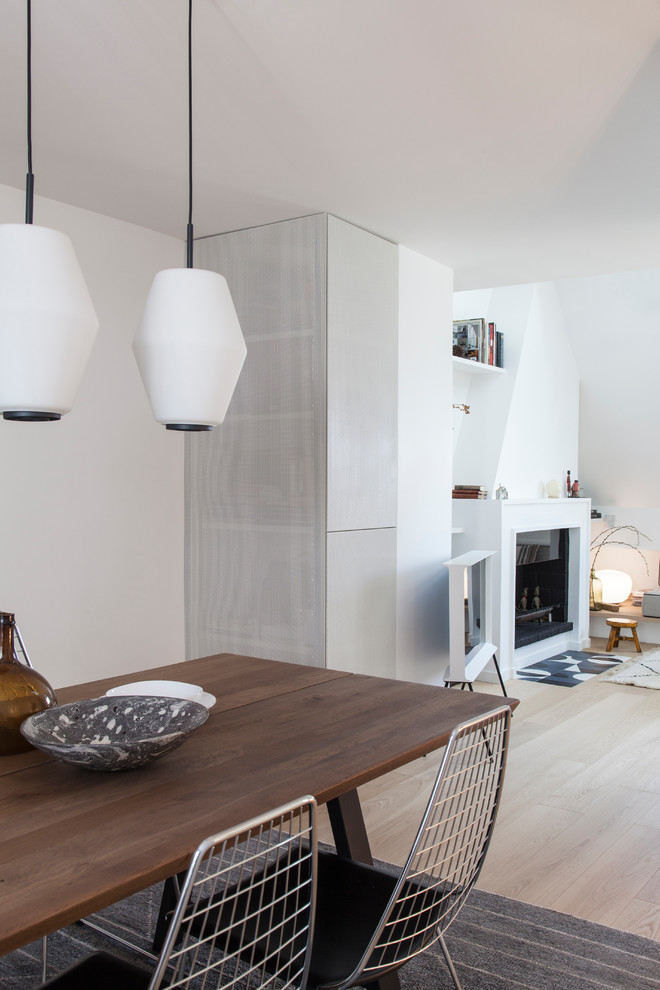 パリにある高級な中くらいなコンテンポラリースタイルのおしゃれなLDK (白い壁、淡色無垢フローリング、標準型暖炉、木材の暖炉まわり、ベージュの床) の写真