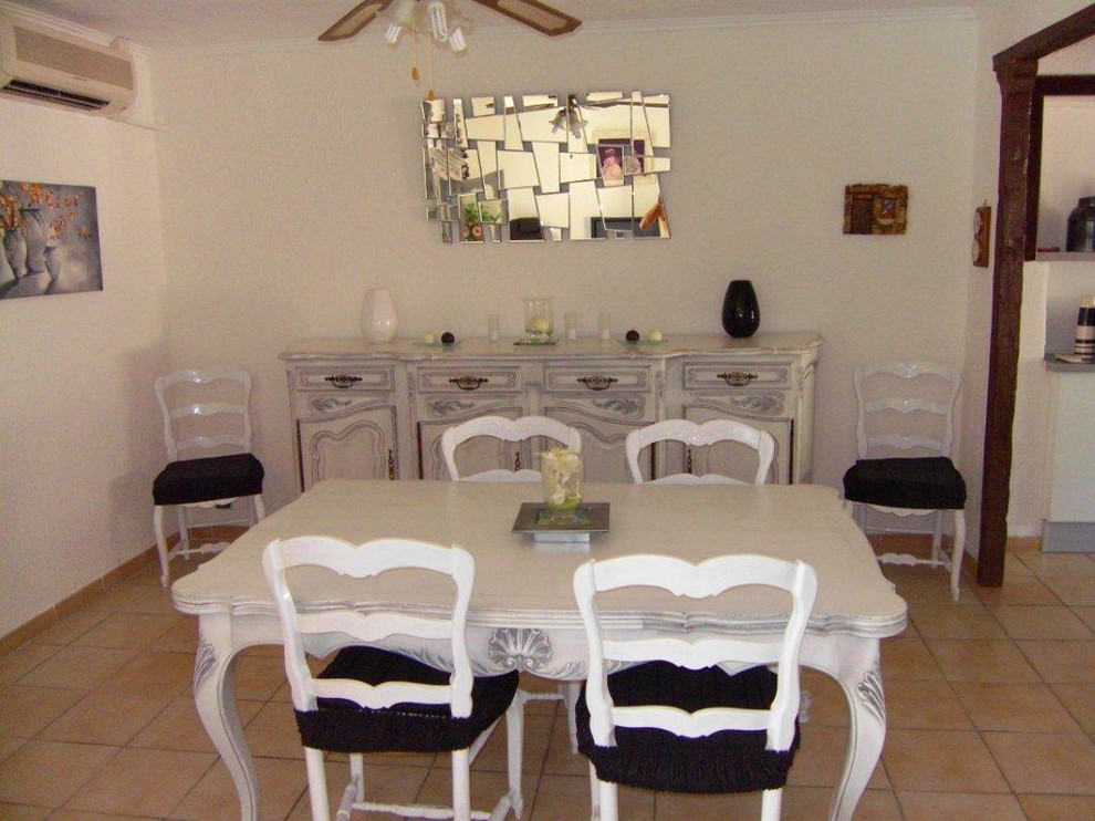 Cette photo montre une salle à manger ouverte sur le salon romantique de taille moyenne avec un mur blanc, un sol en carrelage de céramique et aucune cheminée.