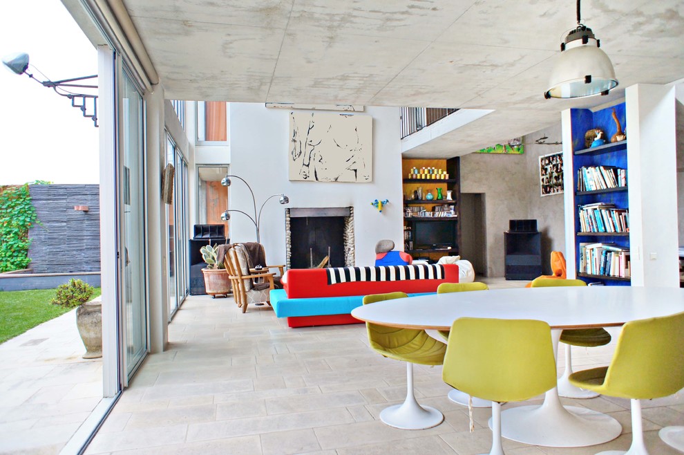 Foto di una sala da pranzo design con pareti bianche, pavimento con piastrelle in ceramica, camino classico e cornice del camino in pietra