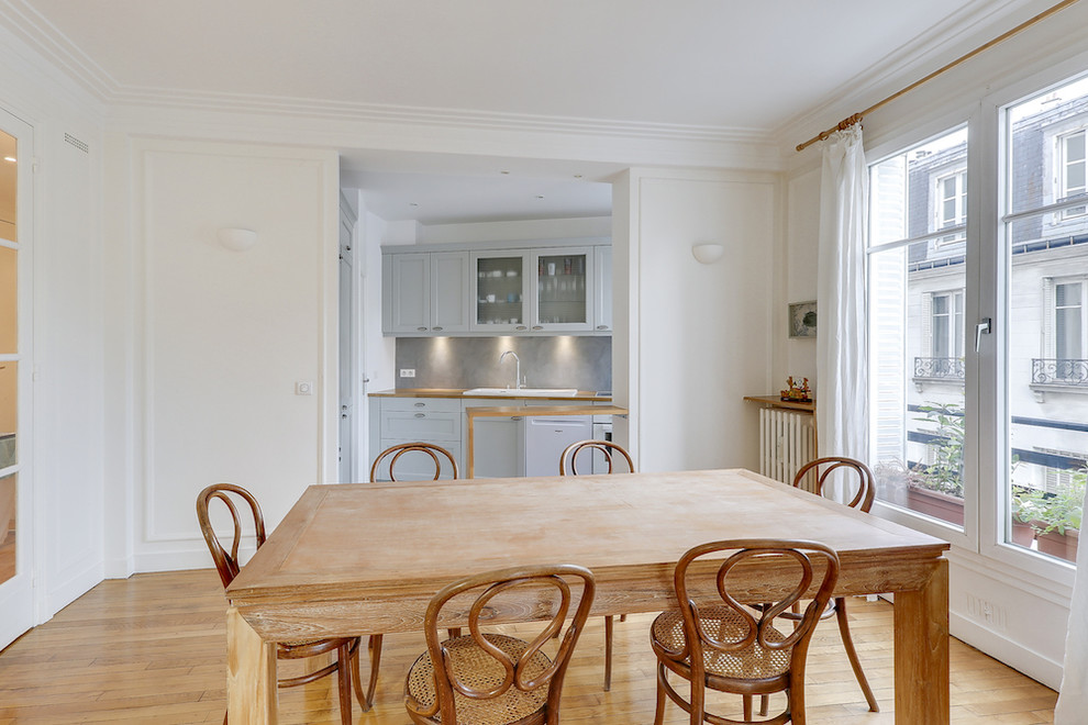 Foto di una sala da pranzo aperta verso la cucina eclettica di medie dimensioni con pareti beige, parquet chiaro e nessun camino