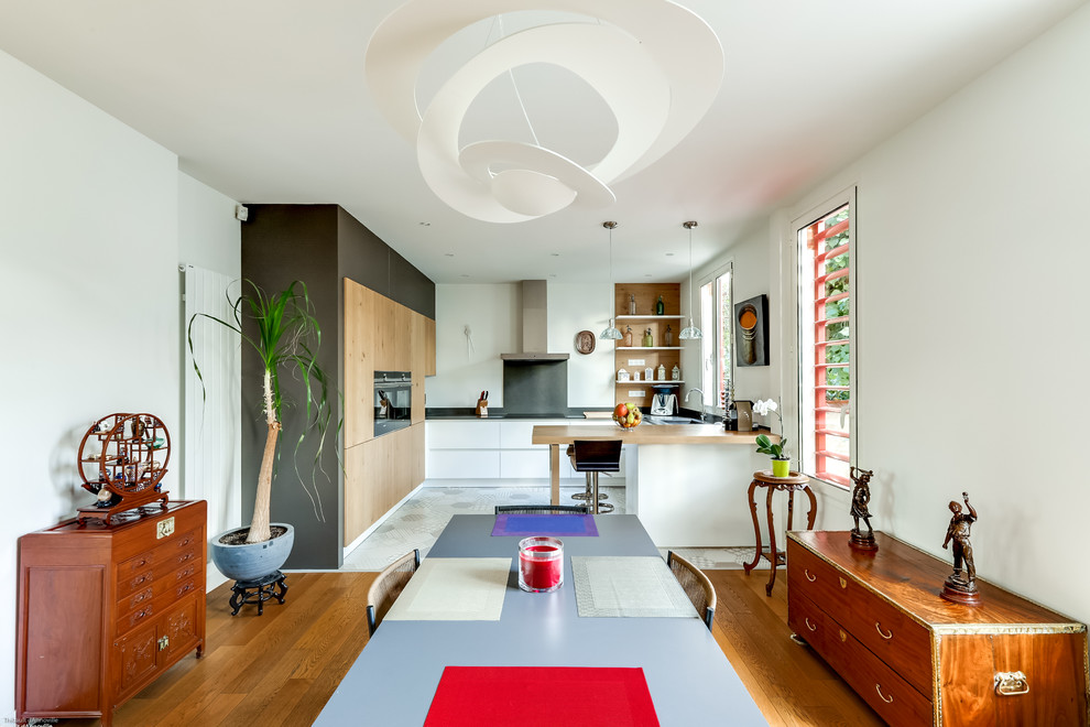Идея дизайна: кухня-столовая среднего размера в стиле фьюжн с белыми стенами и светлым паркетным полом без камина