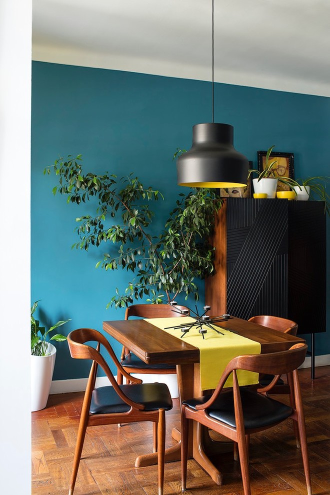 Diseño de comedor vintage pequeño con paredes azules y suelo de madera en tonos medios