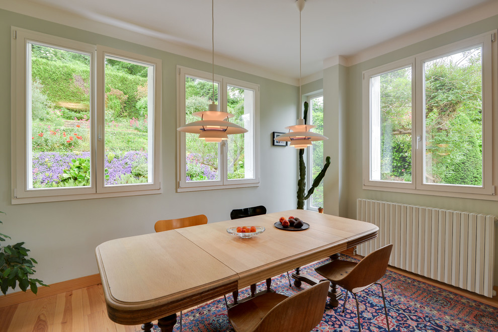 На фото: гостиная-столовая среднего размера в скандинавском стиле с синими стенами, светлым паркетным полом и коричневым полом без камина с