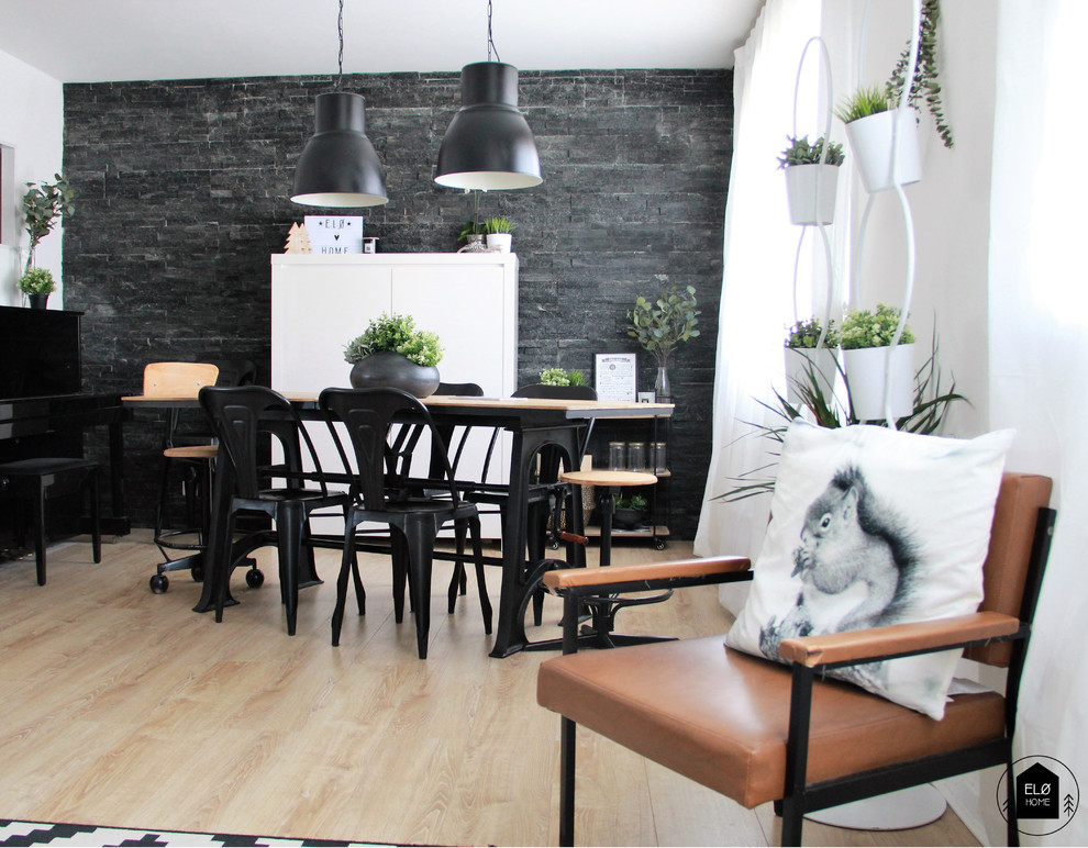 Foto di una sala da pranzo industriale di medie dimensioni con pareti nere, parquet chiaro e pavimento marrone