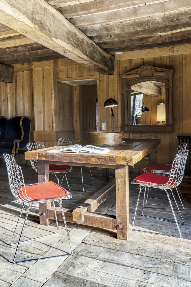 Foto di una sala da pranzo aperta verso il soggiorno country di medie dimensioni con pareti marroni, pavimento in legno massello medio e nessun camino