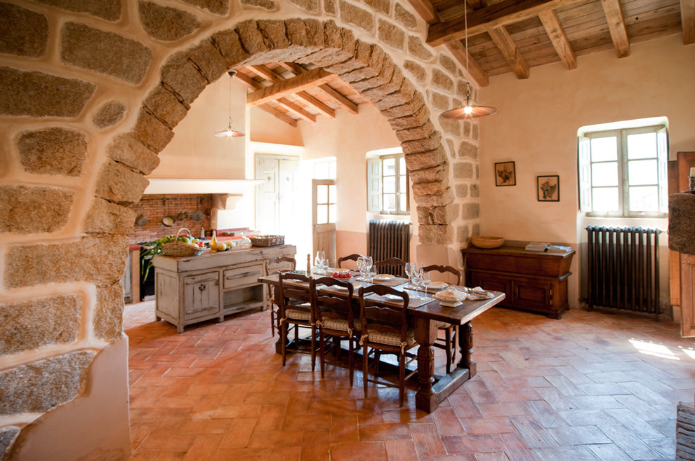 Cette image montre une grande salle à manger ouverte sur la cuisine rustique avec un mur beige et aucune cheminée.