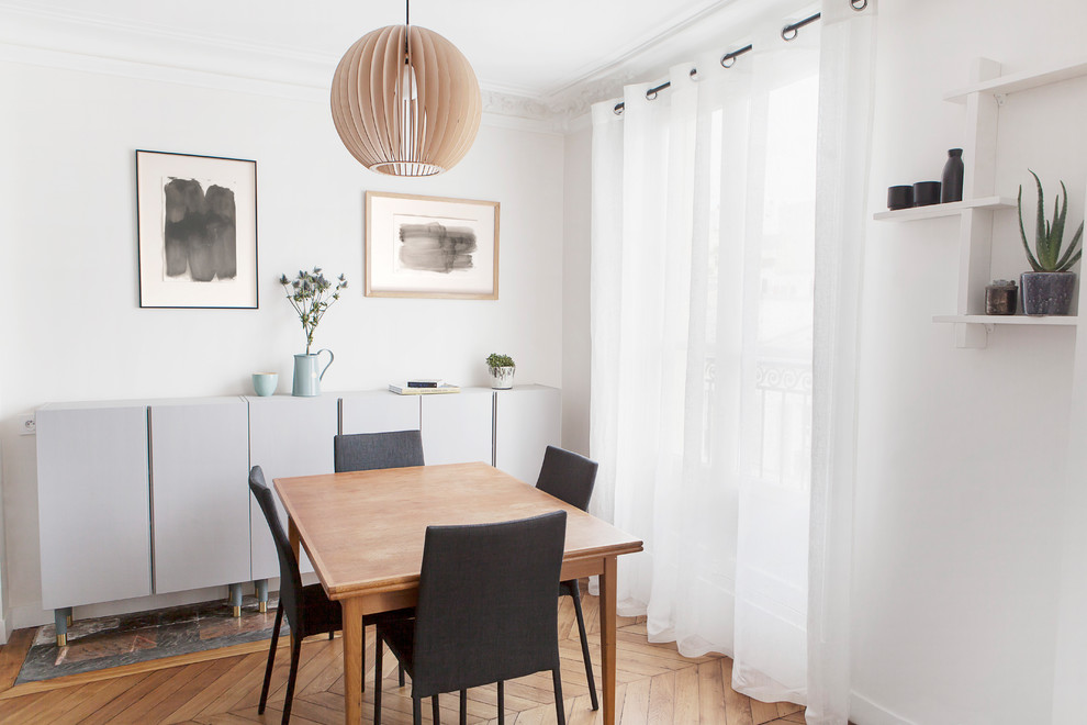Idée de décoration pour une petite salle à manger ouverte sur la cuisine nordique avec un mur beige et parquet clair.