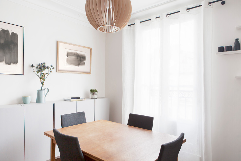 Cette photo montre une petite salle à manger ouverte sur la cuisine scandinave avec un mur beige et parquet clair.
