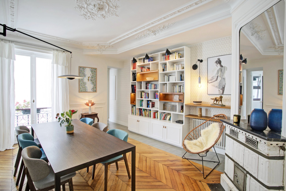 Mittelgroßes, Offenes Modernes Esszimmer mit weißer Wandfarbe, braunem Holzboden, Kamin, Kaminumrandung aus Holzdielen und braunem Boden in Paris