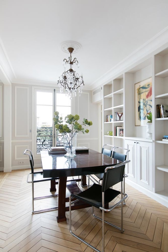 Medium sized eclectic enclosed dining room in Paris with white walls, medium hardwood flooring and no fireplace.