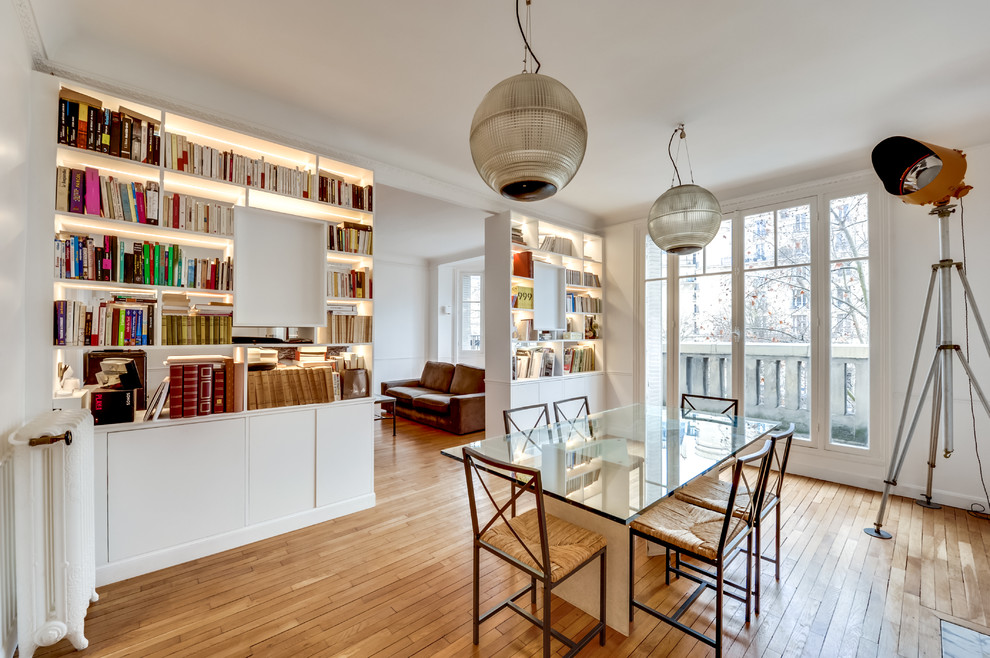 Geschlossenes Modernes Esszimmer ohne Kamin mit weißer Wandfarbe und braunem Holzboden in Paris