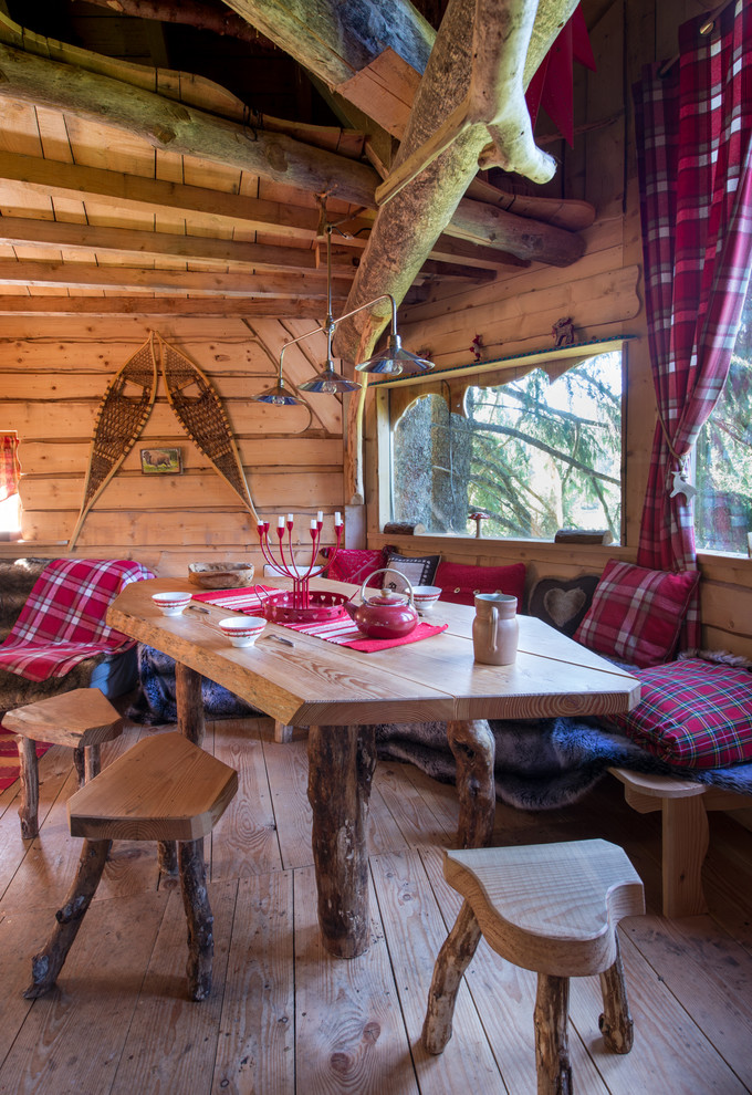 Ejemplo de comedor rural de tamaño medio cerrado sin chimenea con suelo de madera en tonos medios, paredes marrones y cortinas