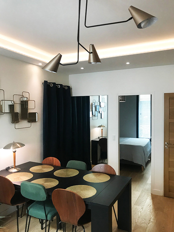 Cette image montre une petite salle à manger ouverte sur le salon design avec un mur blanc, parquet clair et un plafond décaissé.