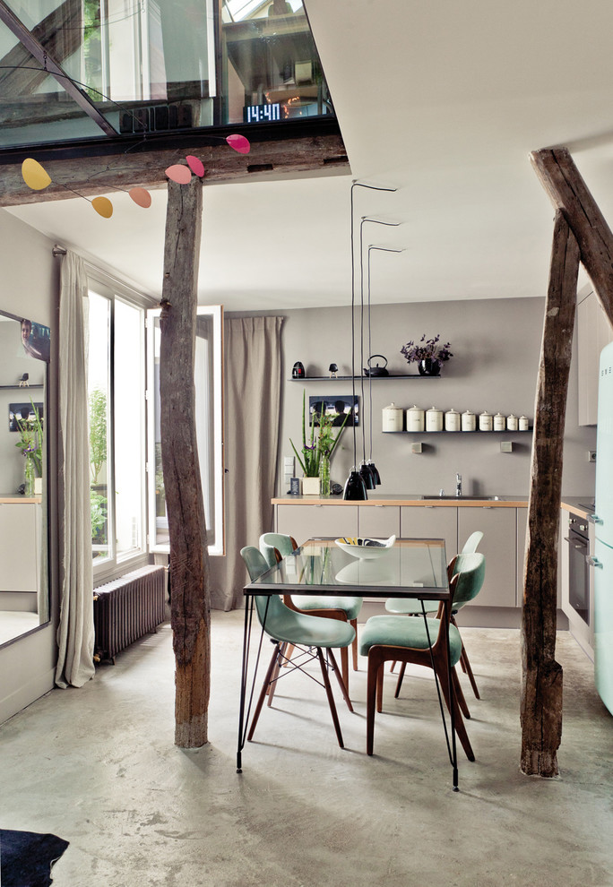 Ispirazione per una sala da pranzo aperta verso la cucina contemporanea con pareti grigie e pavimento in cemento