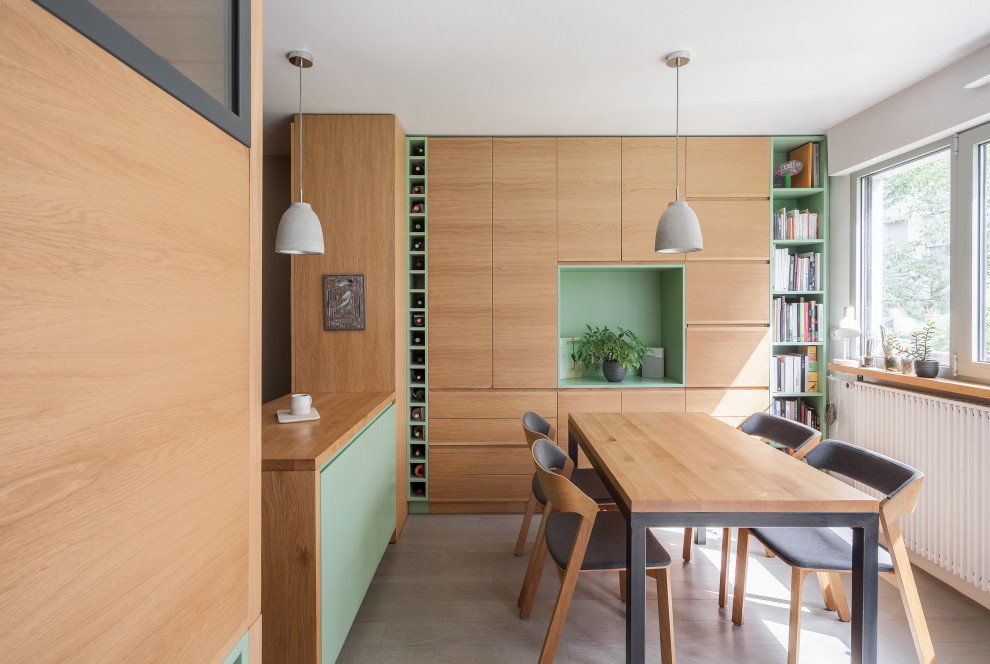 Foto di una piccola sala da pranzo aperta verso la cucina scandinava con pareti bianche, pavimento in legno verniciato, nessun camino, pavimento grigio e pareti in legno