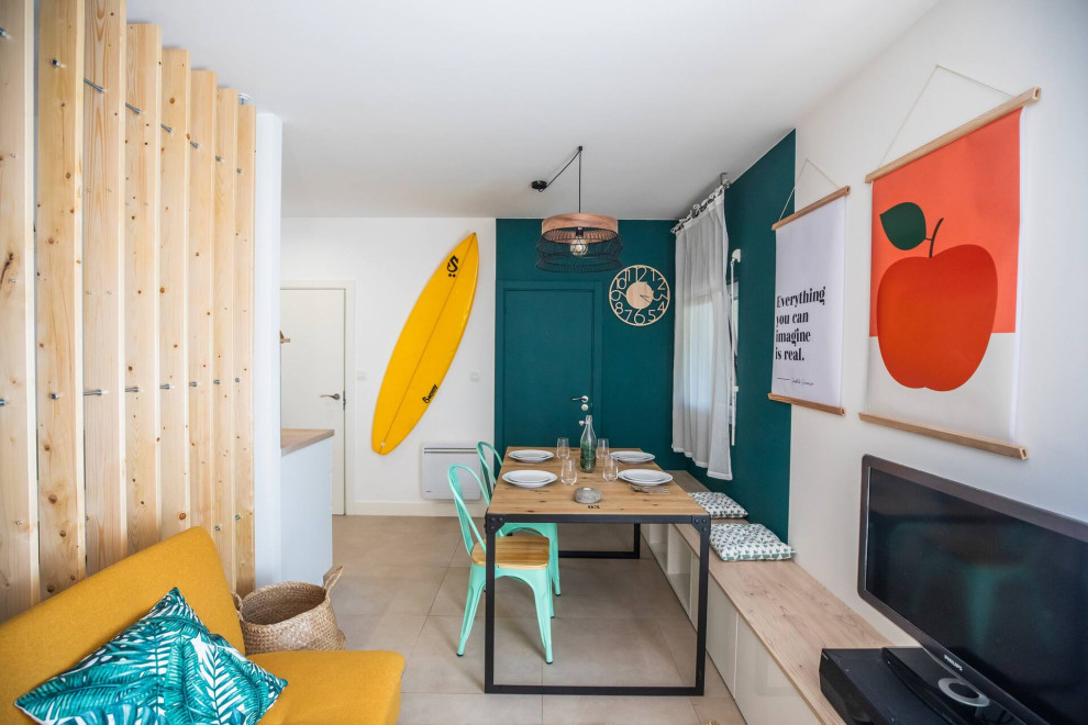 Idée de décoration pour une salle à manger ouverte sur le salon marine avec un mur multicolore, aucune cheminée et un sol beige.