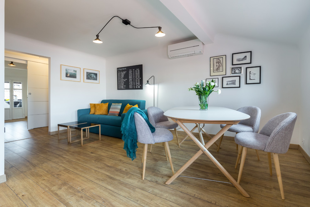 Foto di una sala da pranzo aperta verso il soggiorno minimal di medie dimensioni con pareti bianche, pavimento in legno massello medio e nessun camino