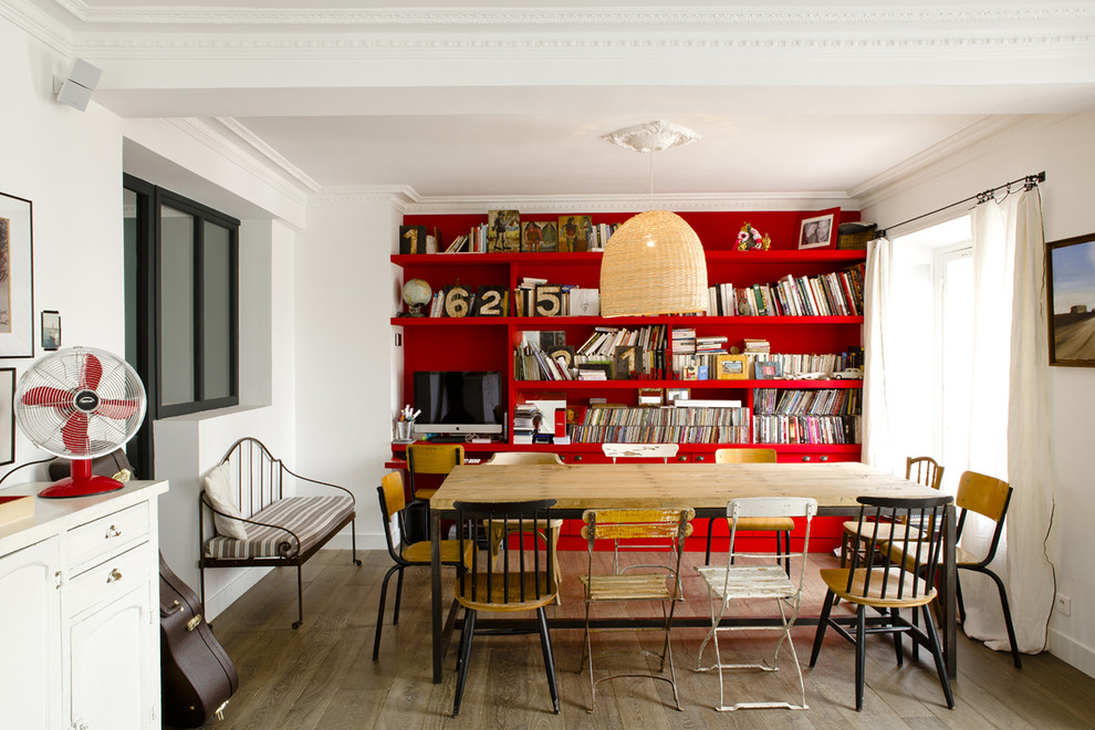Cette image montre une salle à manger ouverte sur le salon design de taille moyenne avec un mur rouge et un sol en bois brun.