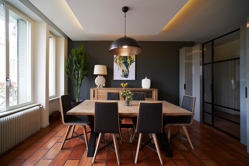 Cette photo montre une salle à manger tendance avec un mur gris, un sol orange et éclairage.