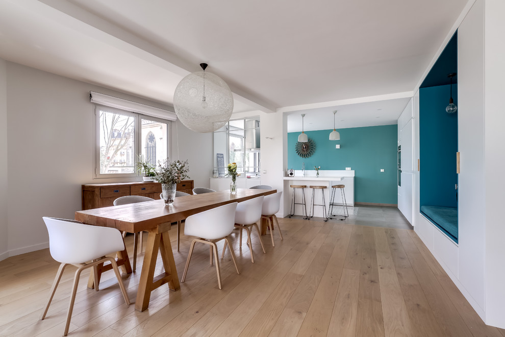 Moderne Wohnküche mit weißer Wandfarbe, hellem Holzboden und beigem Boden in Paris