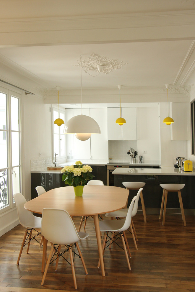 Inspiration pour une salle à manger ouverte sur la cuisine design de taille moyenne avec un mur blanc, parquet foncé et aucune cheminée.