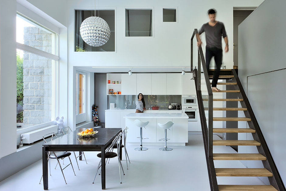 Large contemporary open plan dining room in Lyon with white walls, concrete flooring and grey floors.