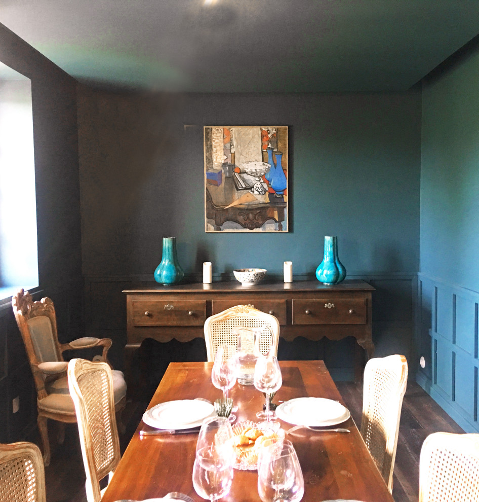 Idee per un'ampia sala da pranzo country chiusa con pareti blu, parquet scuro, nessun camino, pavimento marrone, soffitto ribassato e boiserie