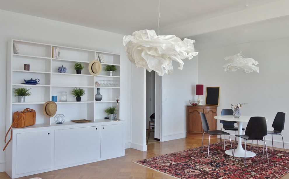 Example of a danish medium tone wood floor and brown floor dining room design in Marseille with white walls