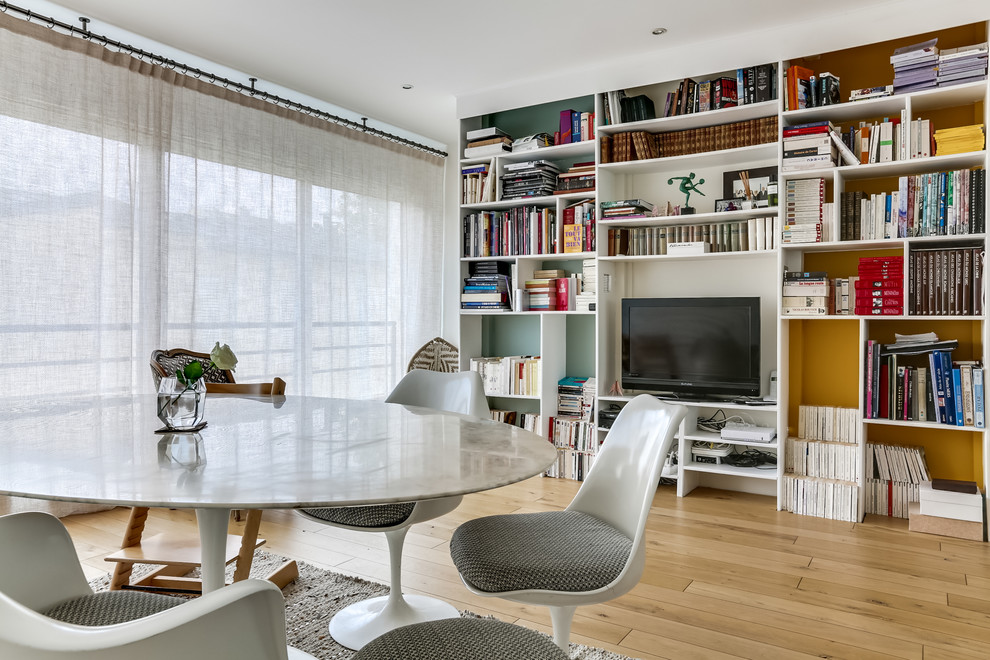 This is an example of a medium sized scandinavian open plan dining room in Paris with white walls, medium hardwood flooring and no fireplace.