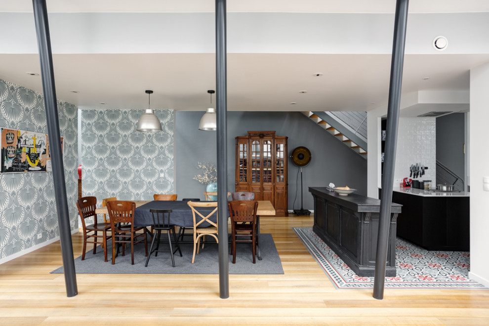 Exemple d'une grande salle à manger ouverte sur le salon éclectique avec un mur multicolore, parquet clair, aucune cheminée et un sol beige.