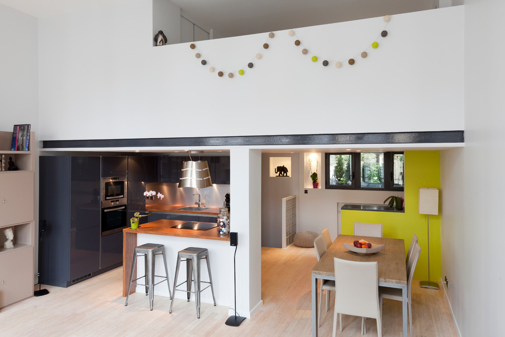 Offenes, Großes Modernes Esszimmer ohne Kamin mit gelber Wandfarbe und hellem Holzboden in Paris