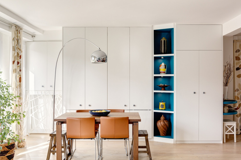 Cette image montre une salle à manger design de taille moyenne avec un mur blanc, parquet clair, aucune cheminée et un sol marron.