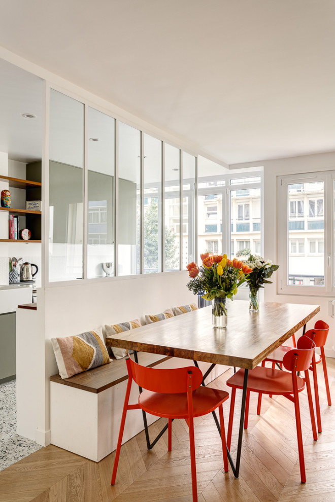 Cette image montre une salle à manger ouverte sur le salon minimaliste de taille moyenne avec un mur blanc, parquet clair, aucune cheminée et un sol beige.