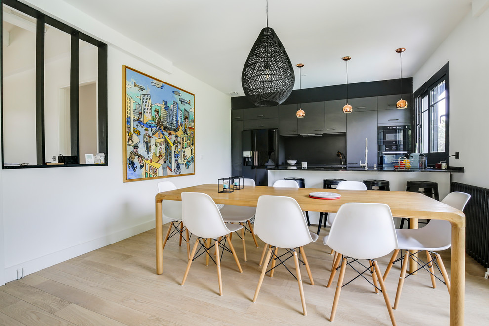 Aménagement d'une salle à manger ouverte sur la cuisine contemporaine avec un mur blanc, parquet clair et un sol beige.
