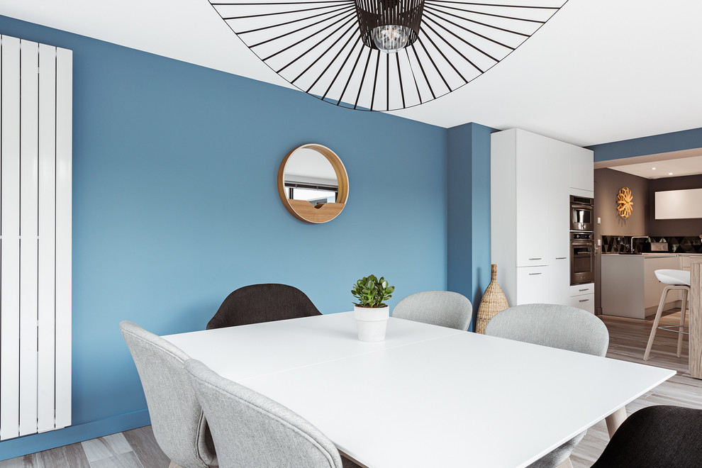Idée de décoration pour une salle à manger design avec un mur bleu.