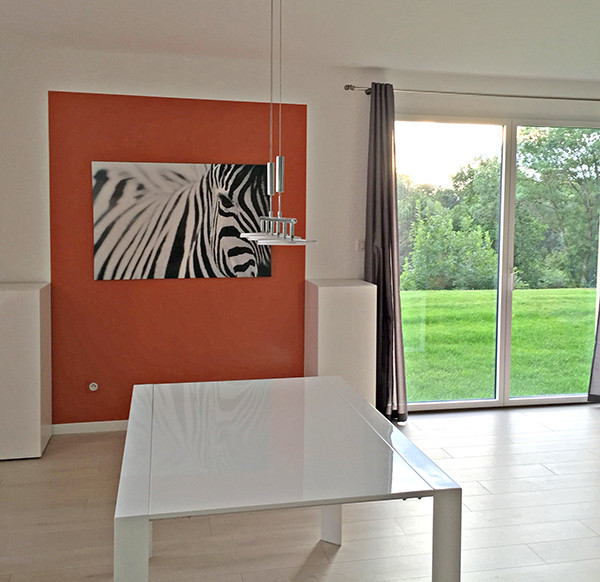 Идея дизайна: гостиная-столовая среднего размера в современном стиле с оранжевыми стенами и светлым паркетным полом