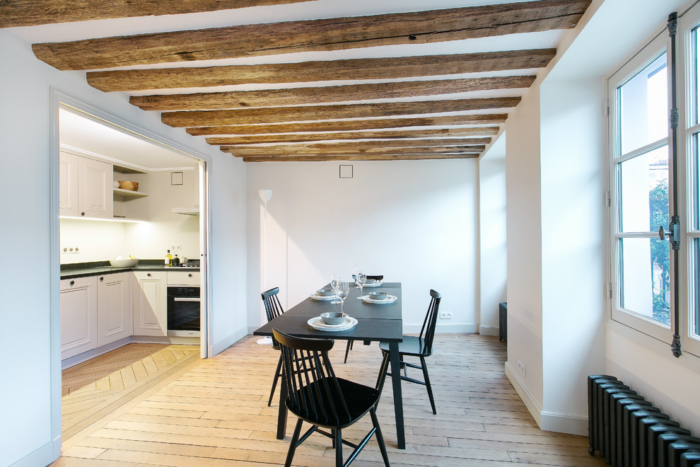 Cette photo montre une salle à manger scandinave fermée et de taille moyenne avec un mur blanc, parquet clair et aucune cheminée.
