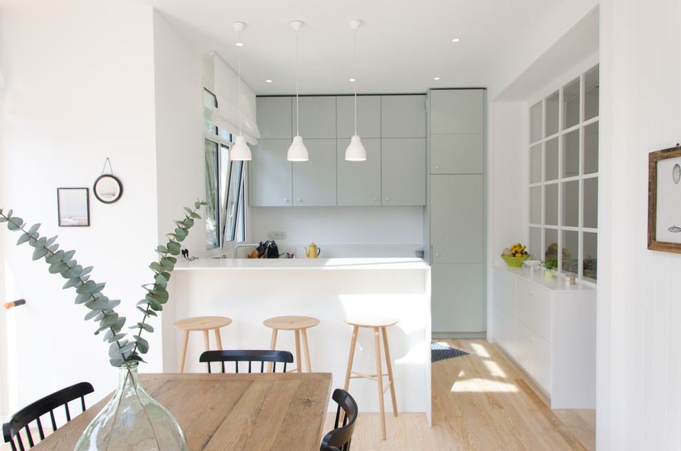 На фото: кухня-столовая среднего размера в современном стиле с белыми стенами и темным паркетным полом без камина с