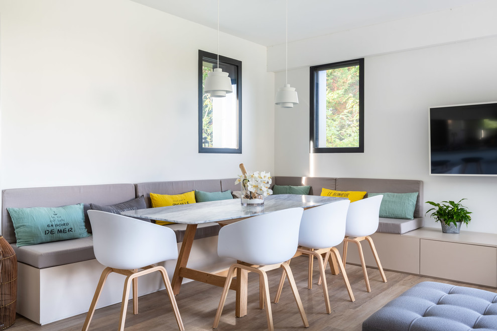 Inspiration för en minimalistisk matplats med öppen planlösning, med vita väggar och ljust trägolv
