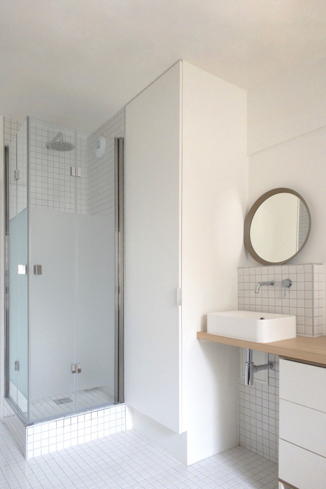 Cette photo montre une salle de bain tendance de taille moyenne avec un mur blanc et un sol en bois brun.