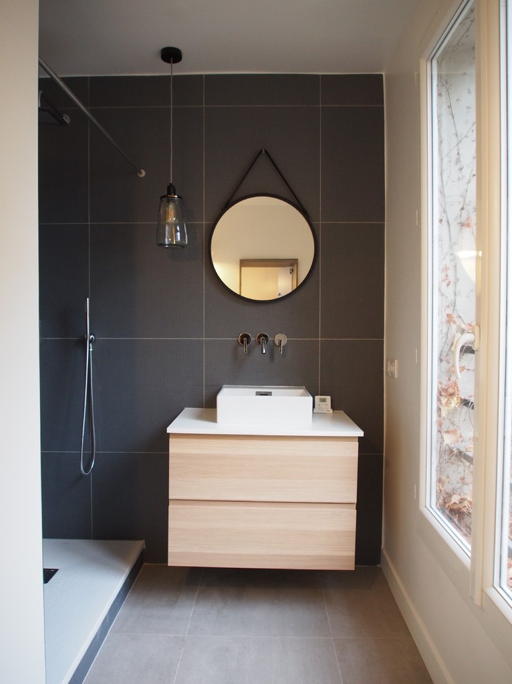 Modern inredning av ett mellanstort en-suite badrum, med skåp i ljust trä, en kantlös dusch, en vägghängd toalettstol, blå kakel, keramikplattor, vita väggar, klinkergolv i keramik, ett fristående handfat och laminatbänkskiva