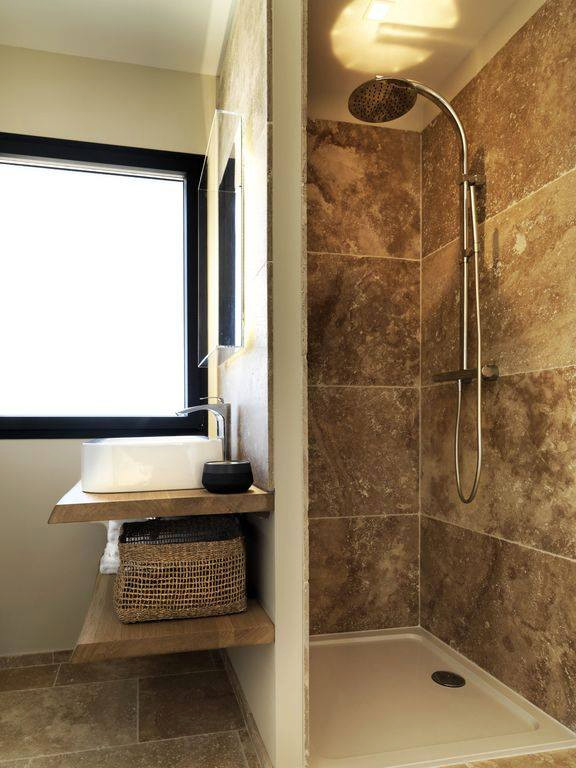 Immagine di una stanza da bagno padronale tradizionale di medie dimensioni con doccia a filo pavimento, piastrelle grigie, piastrelle in travertino, pareti grigie, pavimento in travertino, top in legno, pavimento grigio, doccia aperta, nicchia e un lavabo