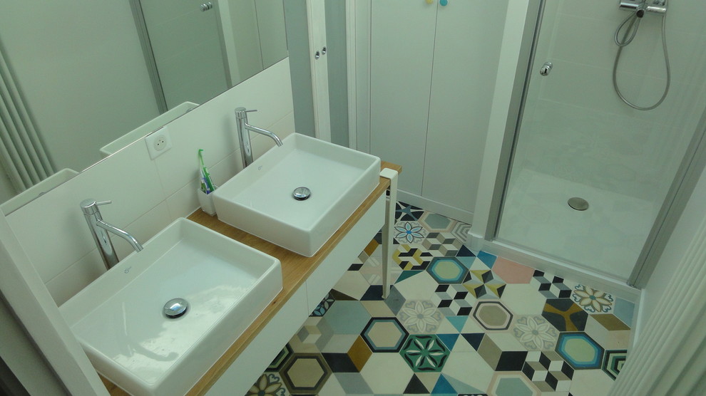 Cette photo montre une douche en alcôve principale tendance de taille moyenne avec un mur blanc, carreaux de ciment au sol, un lavabo posé, un sol multicolore et une cabine de douche à porte battante.