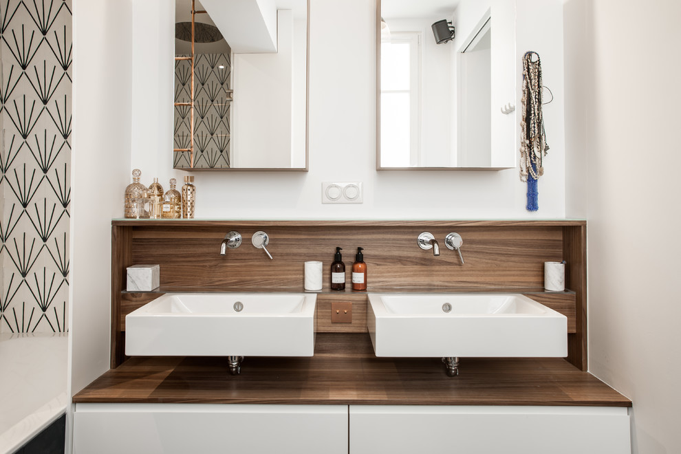 Photo of a contemporary bathroom in Paris with flat-panel cabinets, white cabinets, white walls and a wall-mounted sink.