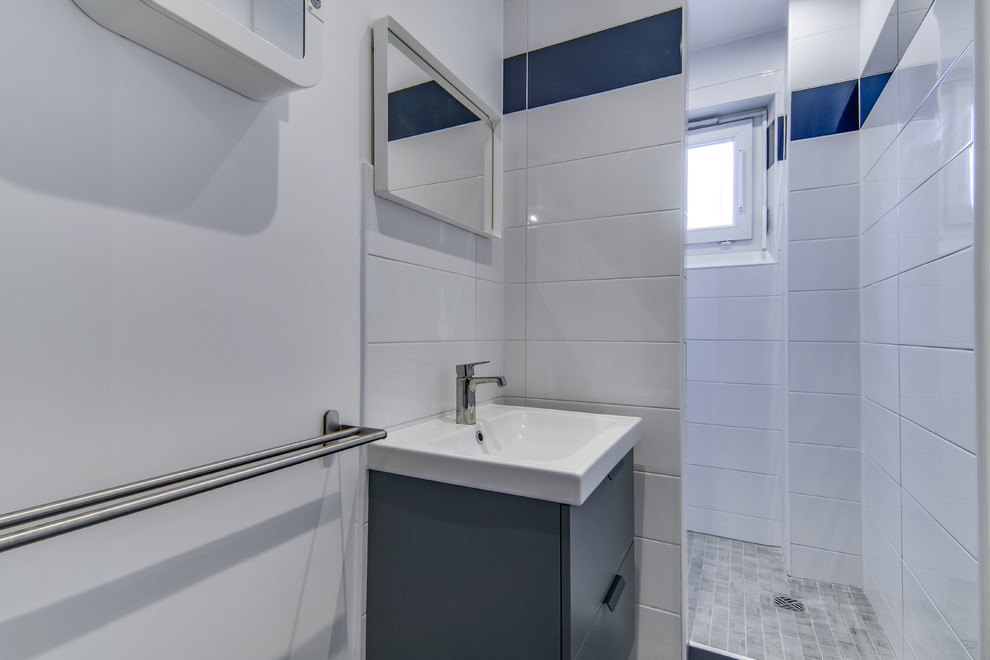Idée de décoration pour une petite salle d'eau tradition avec un placard à porte affleurante, des portes de placard bleues, une douche à l'italienne, un carrelage blanc, un carrelage bleu, des carreaux de porcelaine, un mur bleu, un sol en carrelage de céramique, un lavabo encastré, un plan de toilette en carrelage, un sol gris, aucune cabine et un plan de toilette blanc.