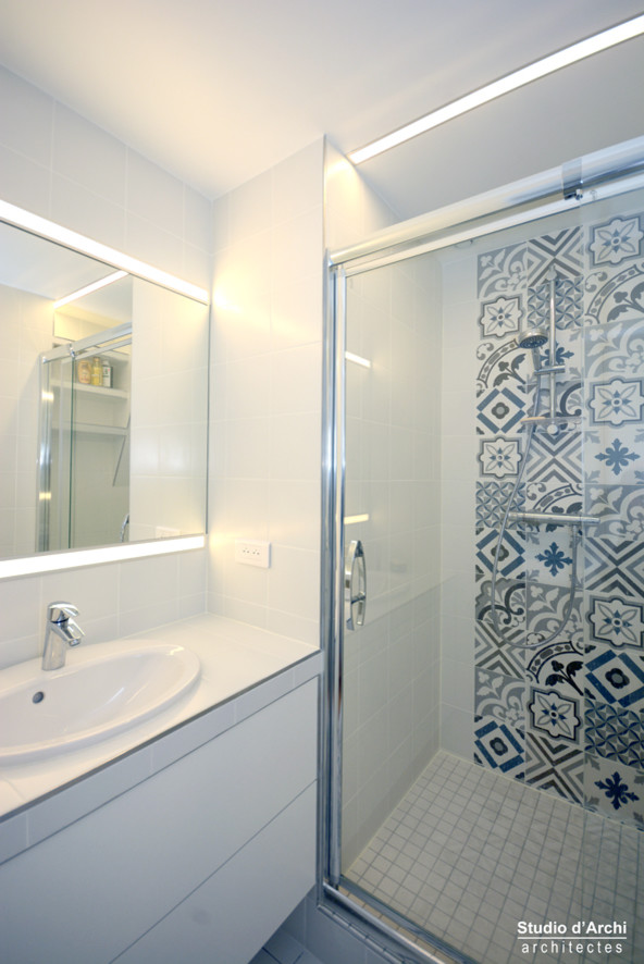 Réalisation d'une petite douche en alcôve principale design avec un placard à porte affleurante, des portes de placard blanches, un carrelage blanc, un plan de toilette en carrelage et un plan de toilette blanc.